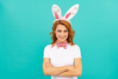 Tavşan kulaklı mutlu Paskalya kadını ve mavi arka planda papyon.