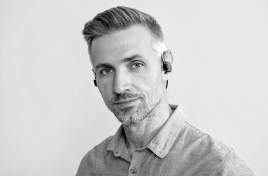 Yeni teknoloji. Başarılı traşsız adam. Çevik iş. Kablosuz kulaklıklı yakışıklı adam.