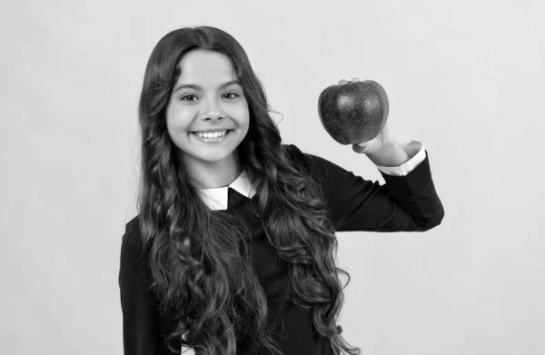 Menina adolescente feliz mostrando maçã de vitamina vermelha para o almoço no fundo amarelo, vitamina — Fotografia de Stock