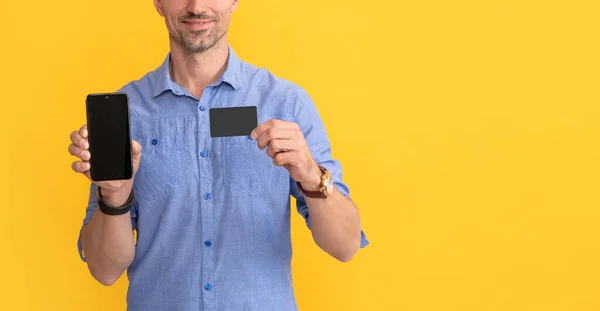 Обрезанный человек показывает смартфон и визитную карточку с копировальным пространством, интернет-банкинг — стоковое фото