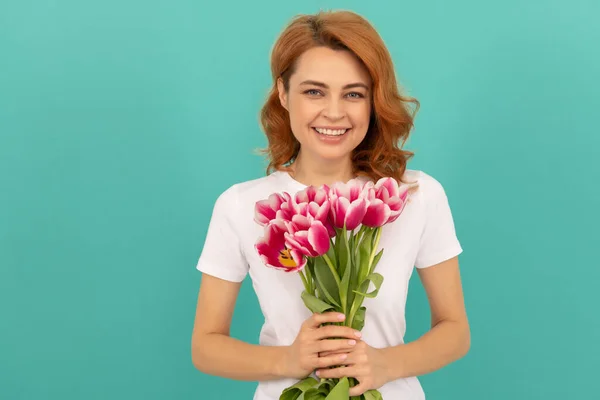Mavi arka planda lale çiçeği buketi olan gülen kadın — Stok fotoğraf