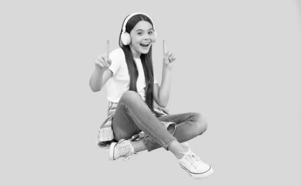Счастливый ребенок девочка слушать музыку в беспроводных наушниках, устройство аксессуар — стоковое фото
