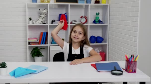 Niño alegre que se divierte jugando con avión de papel en la escuela lección en el aula, diversión — Vídeos de Stock