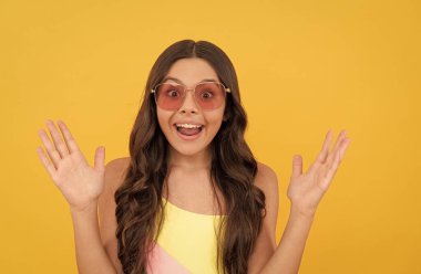 Gözlüklü neşeli çocuk. Havalı genç kız gözlüklerle eğleniyor. Şaşırmış çocuk.