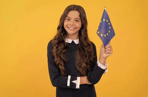Χαρούμενο παιδί που κρατά σημαία της Ευρωπαϊκής Ένωσης σε κίτρινο φόντο. τουριστική θεώρηση — Φωτογραφία Αρχείου
