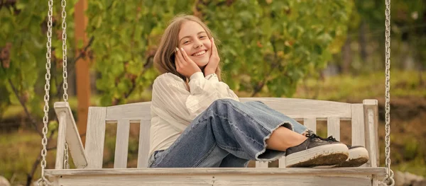 Criança positiva sentar no balanço ao ar livre, felicidade — Fotografia de Stock