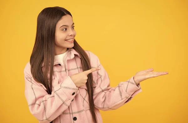 Menina adolescente feliz na camisa. estilo casual miúdo hipster. tween criança em xadrez camisa apresentando produto. — Fotografia de Stock