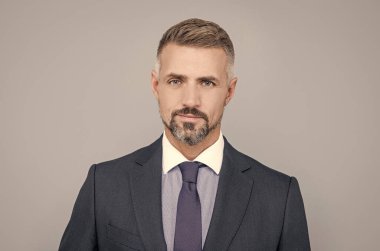 İş adamı gibi giyinmiş kendine güvenen bir iş adamı saçları ağarmış, olgun.