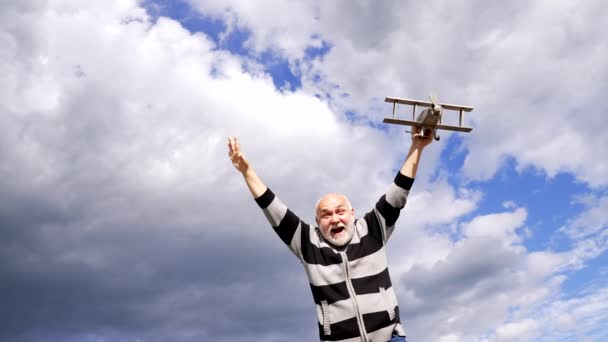 Gelukkige oude man voorstellen vliegen op model vliegtuigen in de lucht, reis — Stockvideo