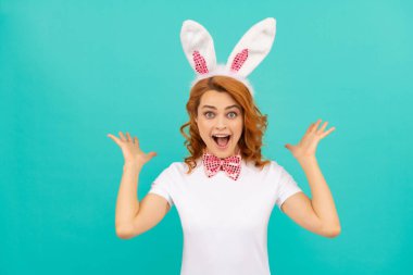 Tavşan kulaklı mutlu Paskalya kadını ve mavi arka planda papyon.