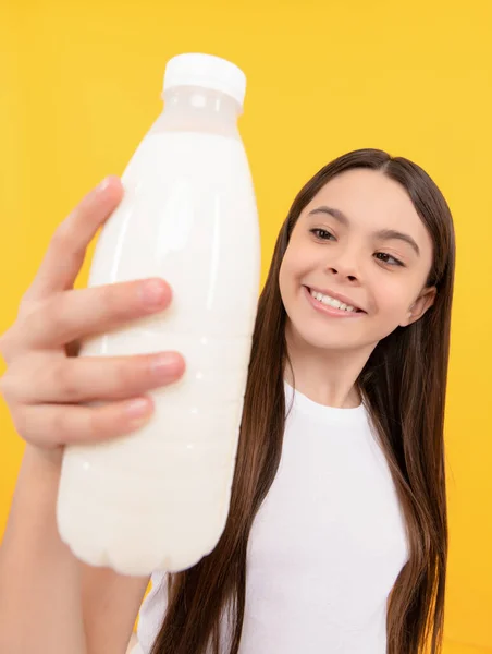 Melkfles in de hand van een gelukkig kind. kind houden zuiveldrank product. — Stockfoto