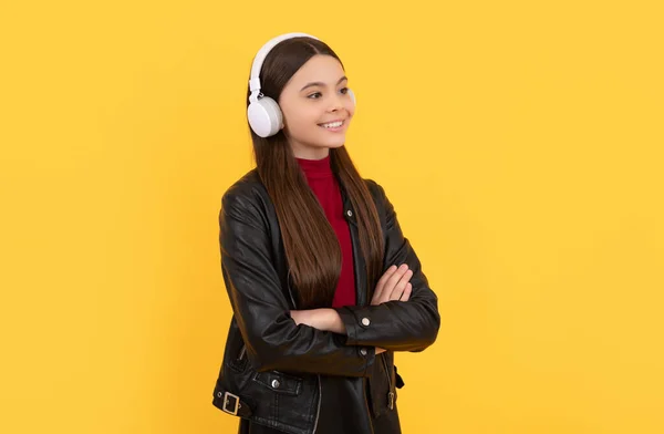 Joyeuse adolescent fille écouter de la musique dans les écouteurs sur fond jaune, e-learning — Photo