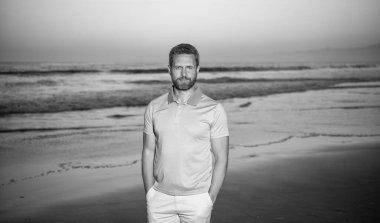 pozitif duygular. Gün batımında deniz üzerinde sakallı neşeli bir adam. Sabah kumsalındaki traşsız adam.