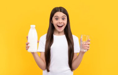 Hayretler içindeki çocuk süt ürünlerini elinde tutuyor. Genç kız süt içecek..