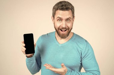 Sakallı mutlu adam akıllı telefon ve terfi gösteriyor.