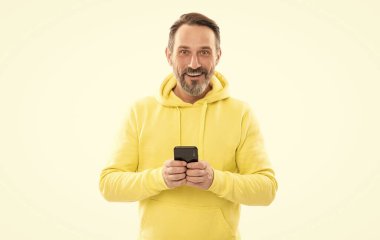 Son sınıf öğrencisi, beyaz telefondan mesaj atıp mesaj yolluyor. Sarı kapüşonlu adam e-postayı kontrol et.