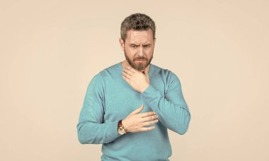 Acı çeken adamın saçları ağarmış. Gri arka plandaki hasta adam. erkek sağlığı.