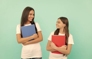 Öğrenci ve öğrenci. Anne ve genç kız çalışmaya hazır. özel öğretmen ve çocuk kitaplarını tutuyor