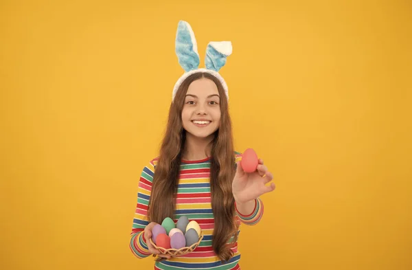 Щаслива великодня дівчина-підліток у вухах кролика, що тримає розфарбовані яйця для святкового полювання, великодні канікули . — стокове фото