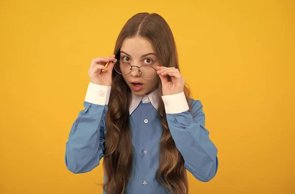 Csak kíváncsiságból. Érdekes lány szemüvegben. Kocka kinézetű gyerek sárga háttér. Vissza az iskolába. — Stock Fotó