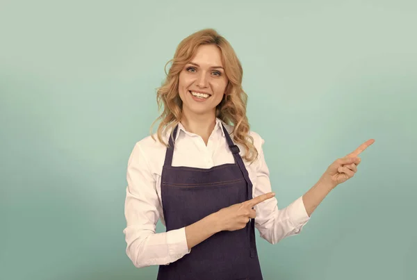 Felice ragazza barista in grembiule cuoco indicando dito, pubblicità — Foto Stock