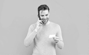 Her zaman bağlanıyor. Cep telefonundan konuşan mutlu adam kartı tutuyor. Kart numarası. Mobil iletişim