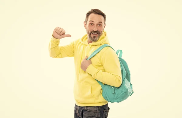 Улыбающийся старшеклассник возвращается в школу одиноким на белом. Белый мужчина в желтой толстовке со школьной сумкой. — стоковое фото