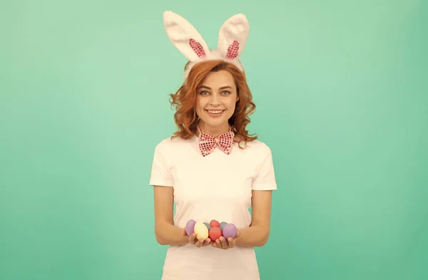Счастливая рыжая женщина в кроличьи уши кролика с окрашенными яйцами, Пасха — стоковое фото