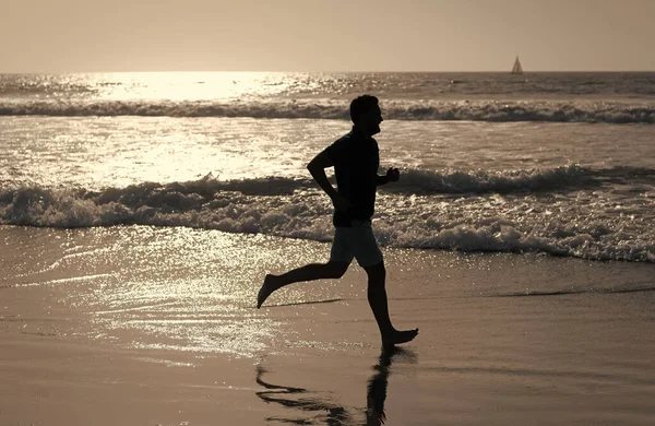 Sportowiec biegnie szybko, aby wygrać w oceanie. poranny trening. zdrowy mężczyzna biegający po plaży. — Zdjęcie stockowe