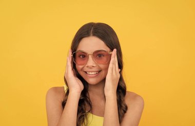 Gözlüklü, uzun saçlı çocuk. Sarı arka planda kıvırcık saçlı mutlu genç kız..