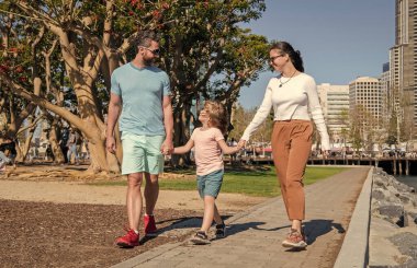 Arkadaş canlısı aile yazın eğleniyor. Mutlu ebeveynler çocuğu yönlendirir..