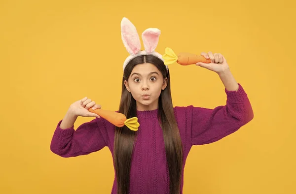 Gezichten trekken. grappig kind in haas oren houden wortel. tiener meisje dragen konijn kostuum — Stockfoto
