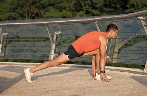 Sportsman segurar posição lunge fazendo rotina de alongamento após o treino atlético ao ar livre, alongamento — Fotografia de Stock