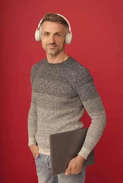 İşine gelince internetten öğreniyorsun. Mutlu adam dizüstü bilgisayar tutuyor. Çevrimiçi ses kursları dinleniyor