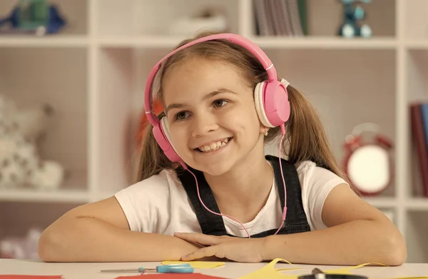 Χαρούμενο παιδί ακούει μουσική στα ακουστικά στο μάθημα του σχολείου στην τάξη, online εκπαίδευση — Φωτογραφία Αρχείου