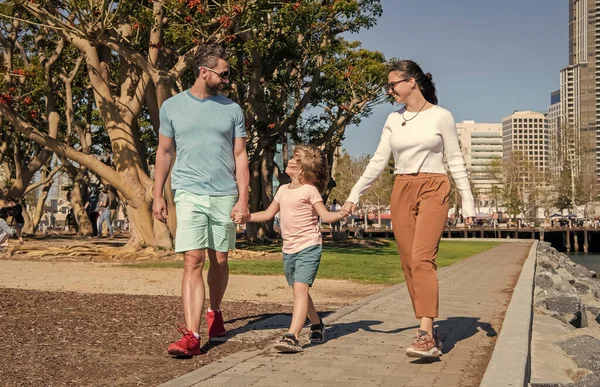 Arkadaş canlısı aile yazın eğleniyor. Mutlu ebeveynler çocuğu yönlendirir..