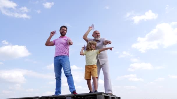 Famiglia felice di bambino ragazzo con papà e nonno dita puntare tenendo aerei di carta cielo-alto, puntando — Video Stock