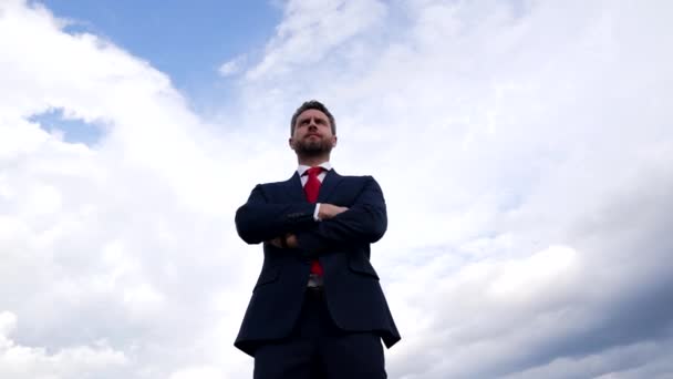 Homme confiant avec succès en costume d'affaires croisé mains sur fond de ciel, succès commercial — Video