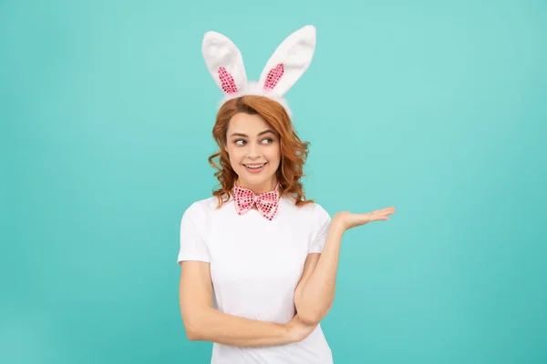 Счастливая пасхальная женщина с кроличьими ушами на синем фоне. презентация продукта — стоковое фото