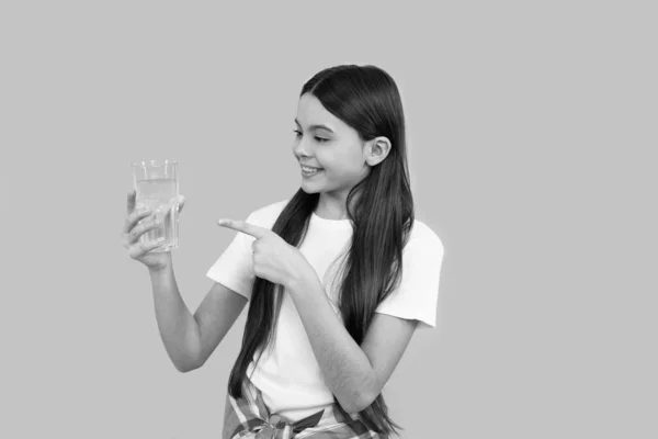 Enfant heureux pointant du doigt sur un verre d'eau pour maintenir l'équilibre quotidien de l'eau dans le corps, l'hydratation. — Photo