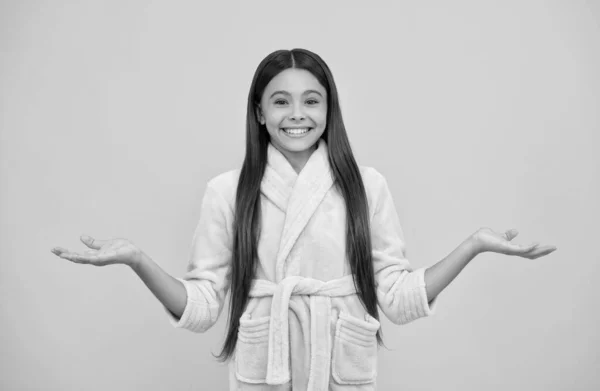 Gelukkig tiener meisje in huis badstof badjas presenteren product en kiezen, kopiëren ruimte, keuze — Stockfoto