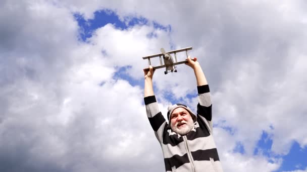 Heureux homme barbe-grise prétendant voler sur un avion en bois dans le ciel, Voyage — Video