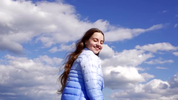 Happy child with long hair in autumn jacket enjoy the sun on sky background, haircare — Stock Video