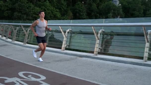 Musculoso joven corredor de ropa deportiva corriendo y entrenamiento de resistencia, trote — Vídeos de Stock