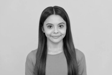 Sarı arka planda uzun saçlı gülümseyen çocuk, portre