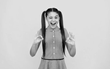 Mutlu göz kırpan kız çocuğu çift halka hareketi göster sarı arka plan, tamam