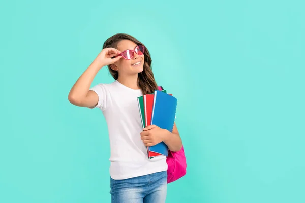 Criança feliz com mochila e copybook em óculos de sol prontos para estudar na escola, educação — Fotografia de Stock
