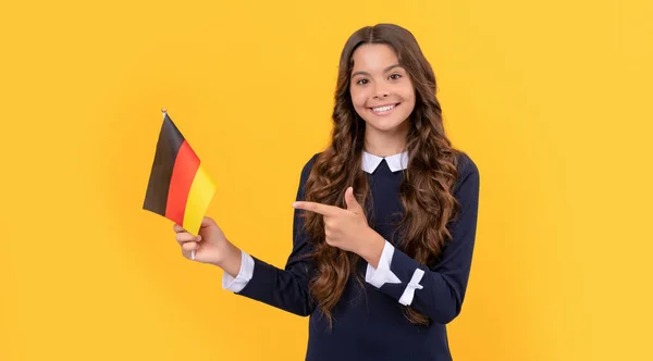 Happy kid pointing finger on german flag yellow background, eurozone — Foto de Stock