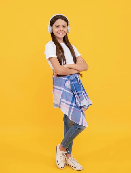 Glückliches Kind in lässigem Musikhören mit Kopfhörer gelber Hintergrund, melomanisch — Stockfoto
