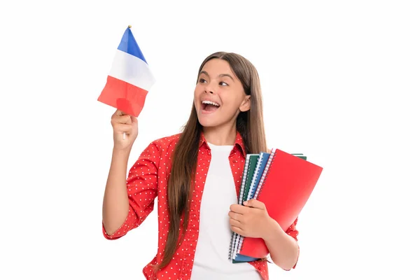 Ταξιδέψτε στη Γαλλία. εκμάθηση ξένης γλώσσας. έκπληκτος έφηβος κορίτσι κατέχουν γαλλική σημαία και βιβλίο εργασίας. — Φωτογραφία Αρχείου